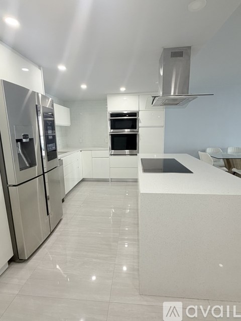 A modern kitchen with stainless steel appliances and a large island.