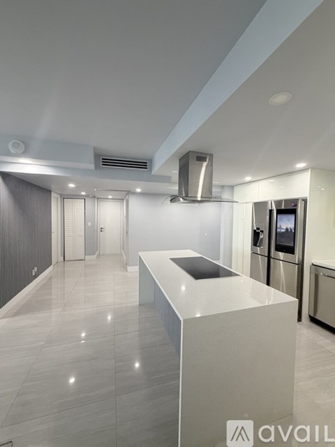 A modern kitchen with a white countertop and stainless steel appliances.