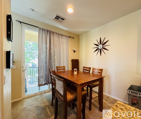 A dining room with a wooden table and chairs.