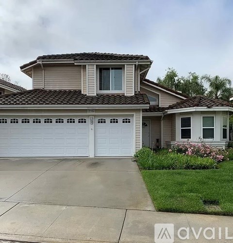 A two-story house with a garage and a driveway.