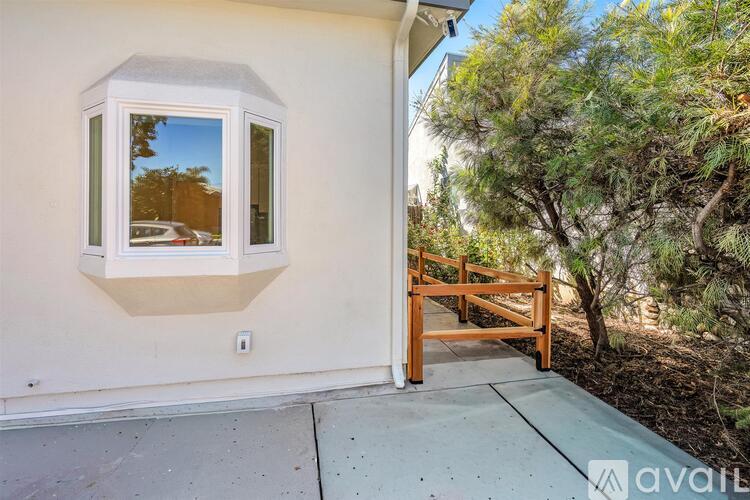 A white house with a window and a wooden gate.