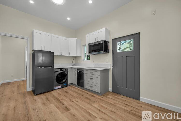 A kitchen with a fridge, dishwasher, microwave, and cabinets.