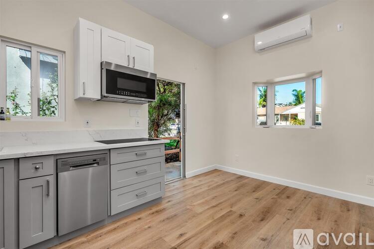 A kitchen with a white countertop and a microwave above it.