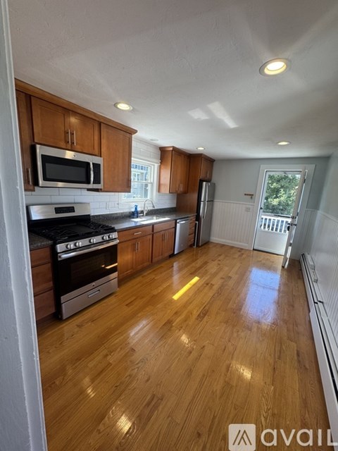 A kitchen with wooden cabinets and a stainless steel refrigerator.