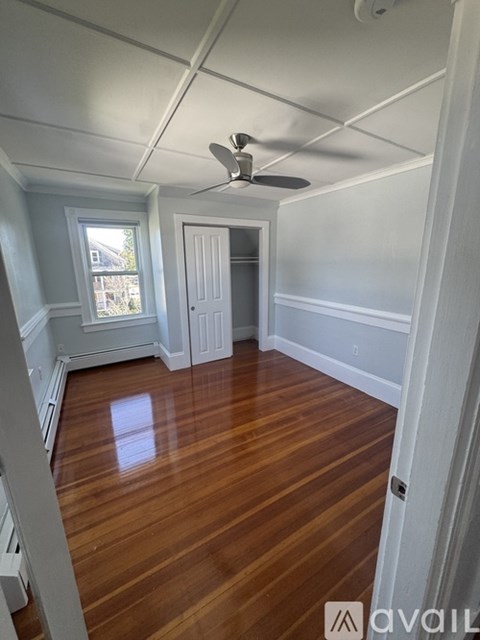 A room with wooden floors and a ceiling fan.