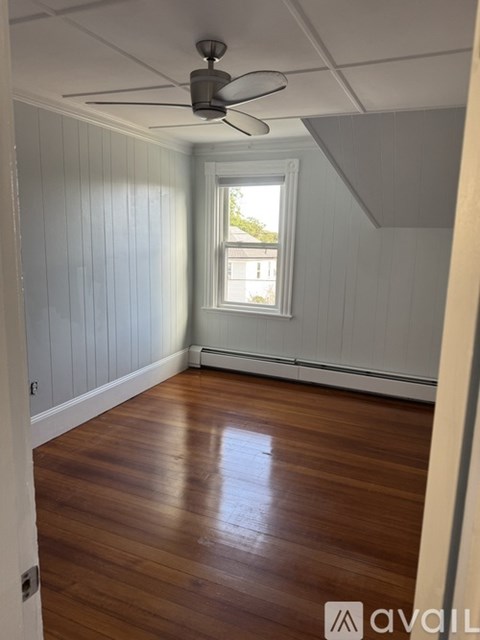 A room with wooden floors and a ceiling fan.