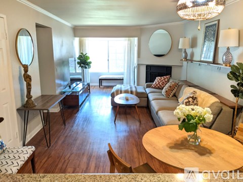 A living room with a wooden floor and furniture.