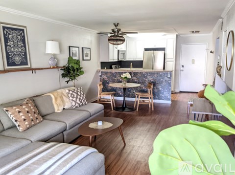 A living room with a grey couch and a green chair.