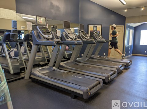A man is running on a treadmill in a gym.