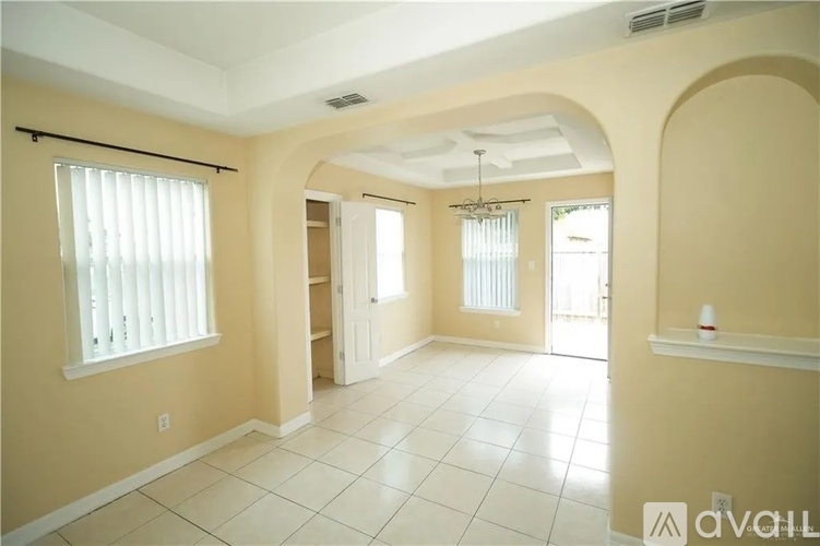 A spacious room with a tiled floor and a ceiling fan.
