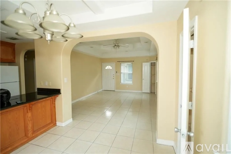A kitchen with a black counter top and white tiled floor.