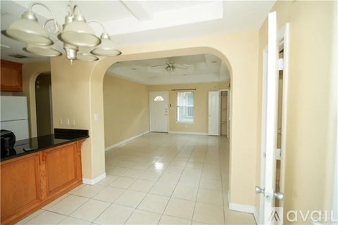 A kitchen with a black counter top and white tiled floor.