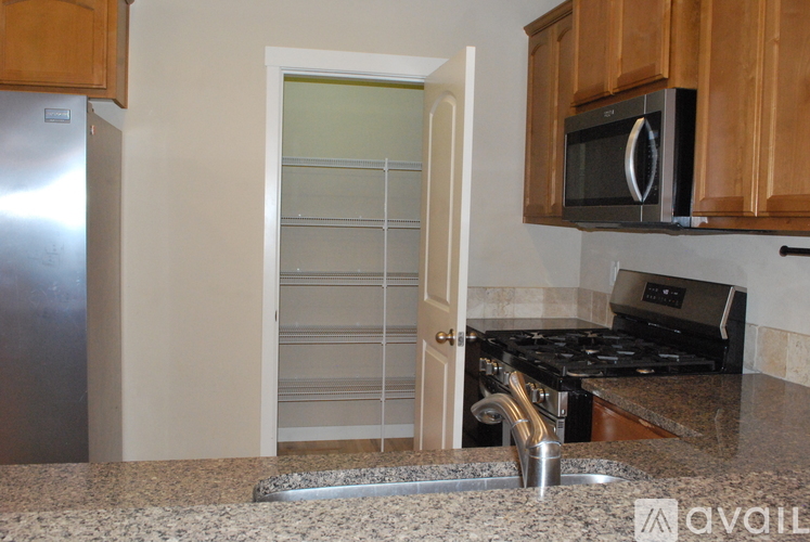 A kitchen with a stove, sink, and microwave.