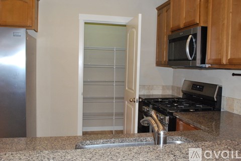 A kitchen with a stove, sink, and microwave.