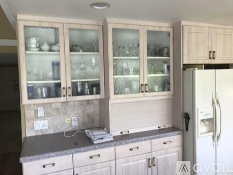 A kitchen with a white refrigerator and wooden cabinets.