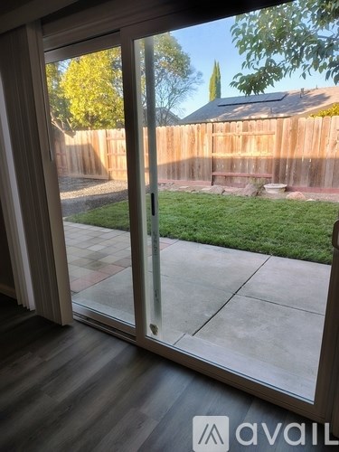 A glass door with a wooden fence and green grass in the background.