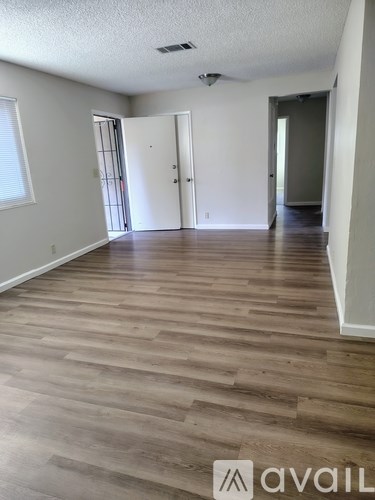A room with wooden flooring and white walls.