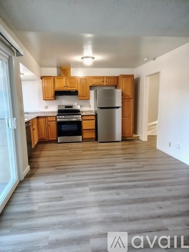 A kitchen with wooden cabinets and a refrigerator.