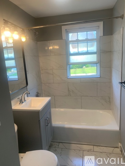 A bathroom with a white toilet, sink, and bathtub.