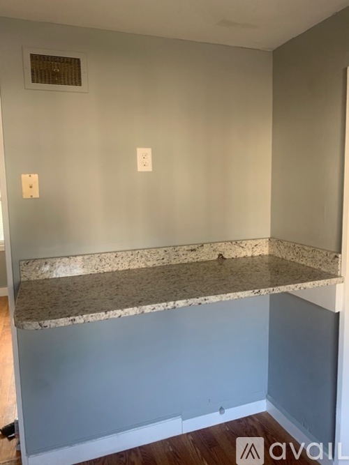 A room with a marble countertop and two switches on the wall.
