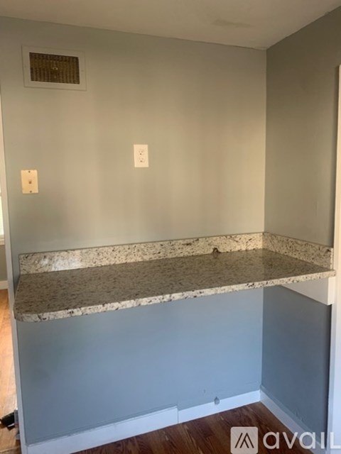 A room with a marble countertop and two switches on the wall.