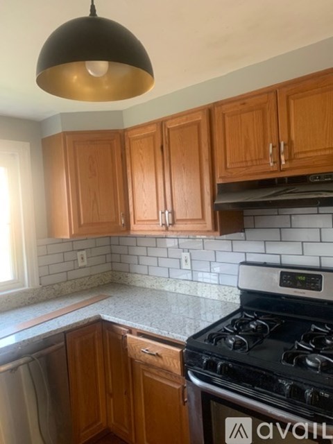 A kitchen with wooden cabinets and a black stove.