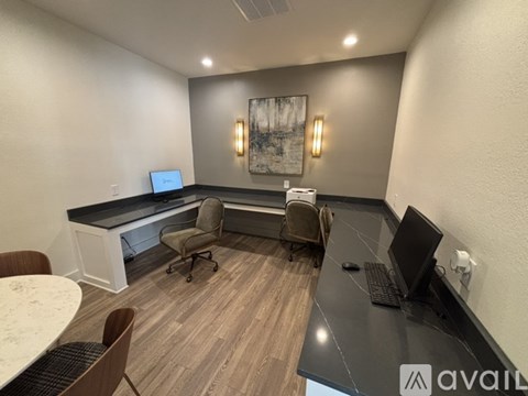 A modern office space with a desk, chairs, and a computer.