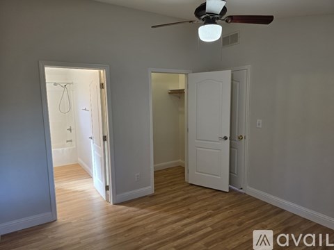 A room with a ceiling fan and two doors.