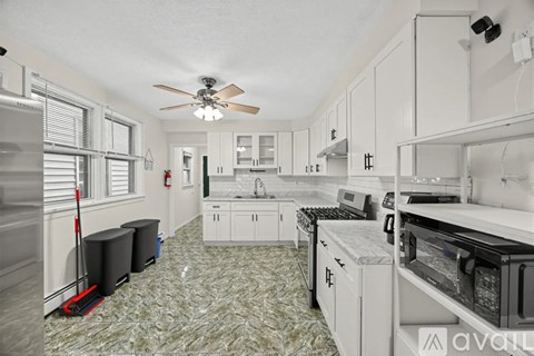A kitchen with white cabinets and a patterned floor.