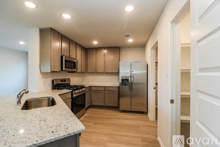 A kitchen with a granite countertop and stainless steel appliances.