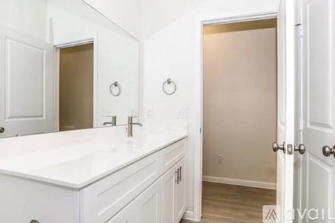 A bathroom with a white counter top and a white door.