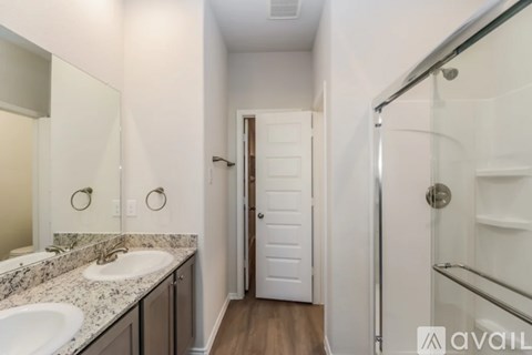 A bathroom with a sink, mirror, and shower.
