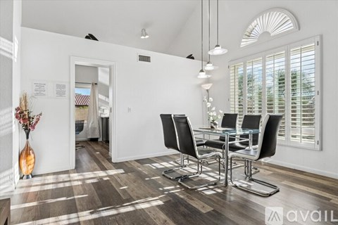 A modern living room with a dining table and chairs.