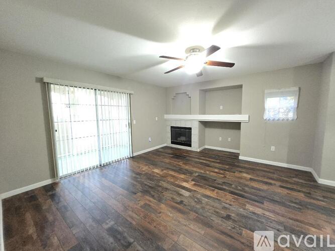 A room with wood flooring and a fireplace.
