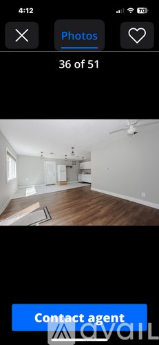 A room with a ceiling fan and wooden flooring.