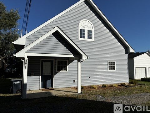 A house with a grey siding and a black door is available for sale.