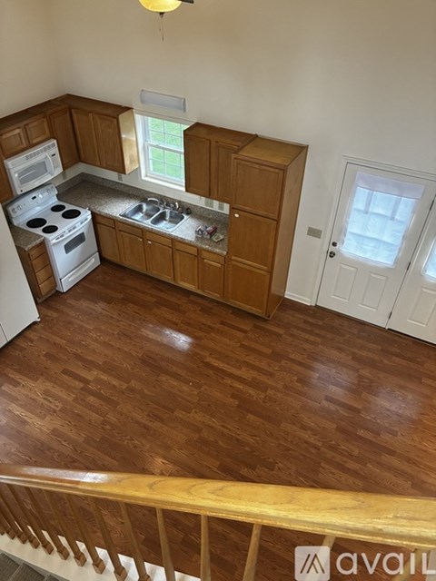 A kitchen with wooden cabinets and a white stove top oven.
