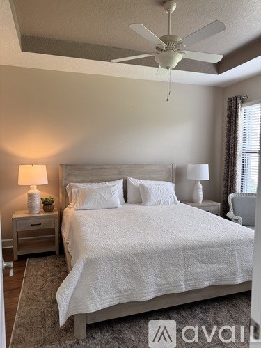 A bedroom with a large bed and a ceiling fan.