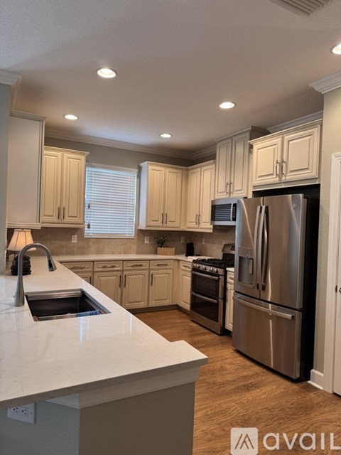 A kitchen with a white countertop and stainless steel appliances.