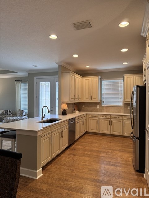 A kitchen with wooden cabinets and a black refrigerator.