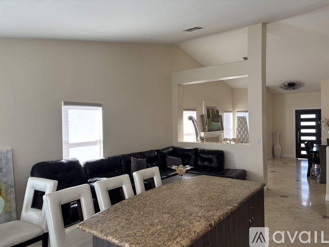 A modern living room with a black couch and a granite countertop.