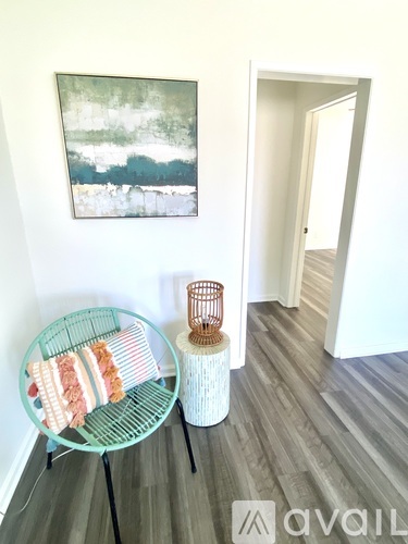 A room with a green chair and a painting on the wall.
