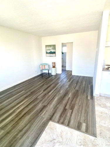 A room with a wooden floor and a painting on the wall.