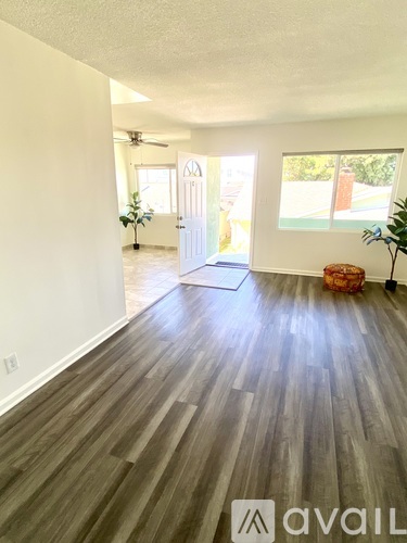 A room with wooden flooring and a white door.