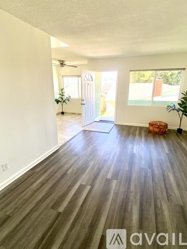A room with wooden flooring and a white door.