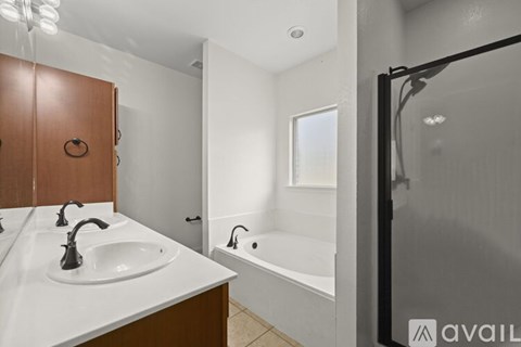 A bathroom with a white sink and a brown cabinet.