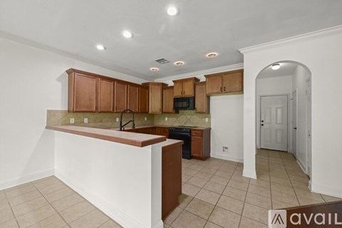 A kitchen with brown cabinets and a white counter.
