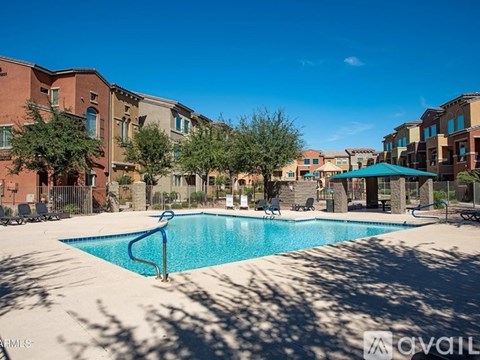 A swimming pool surrounded by apartment buildings on a sunny day.