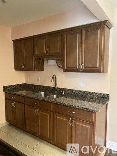 A kitchen with brown cabinets and granite countertops.