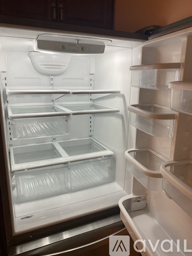 A white refrigerator with the door open and shelves inside.